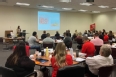 NE AgrAbility staff training OTs and PTs in a large classroom with students at round tables.